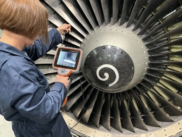 A NDT Inspector using Ultra Sonic Testing on a Jet Engine Turbine Blade.