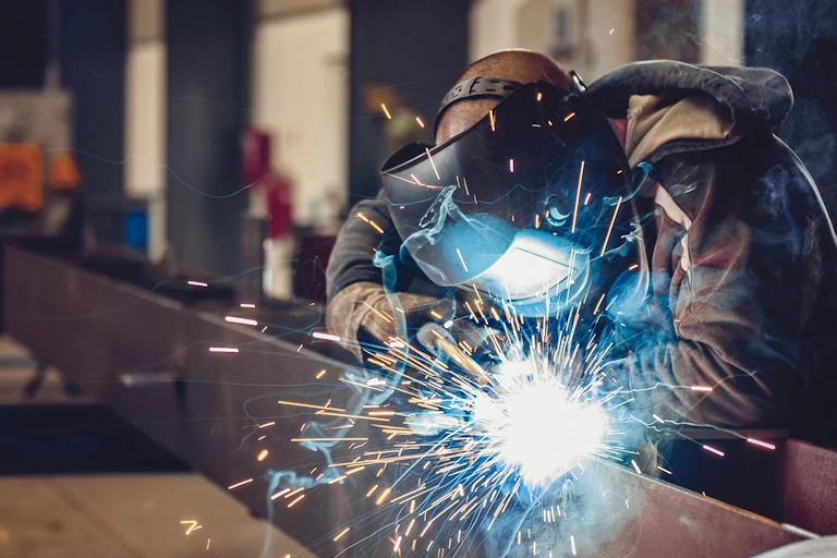 MIG Welder putting together a truss for a Navy Ship.